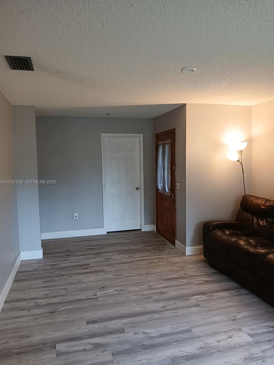 10210 Southwest 175th Street Miami, FL 33157 - Photo 5 of 14 a view of a livingroom with wooden floor and dresser