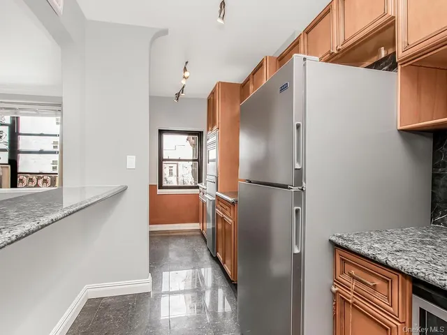 a kitchen with stainless steel appliances granite countertop a refrigerator and a sink
