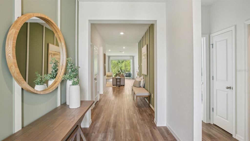 17542 Maple Grv Road Land O Lakes, FL 34638 - Photo 2 of 34 a view of a hallway with wooden floor a glass table and windows