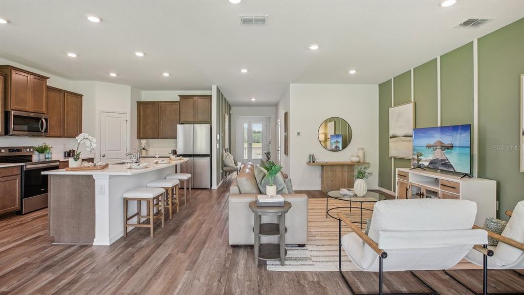 17542 Maple Grv Road Land O Lakes, FL 34638 - Photo 7 of 34 a large kitchen with kitchen island a large counter top space a sink stainless steel appliances and cabinets