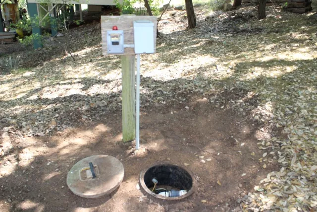 a view of a lake with a yard and large trees