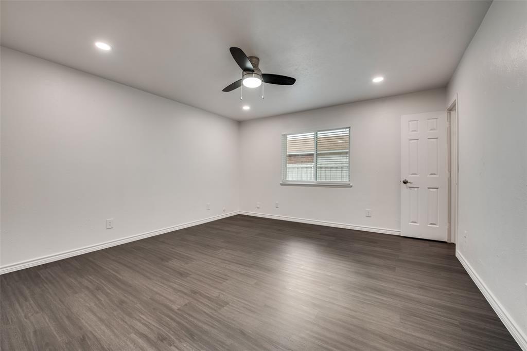 5412 Rice Drive The Colony, TX 75056 - Photo 14 of 17 an empty room with wooden floor ceiling fan and windows