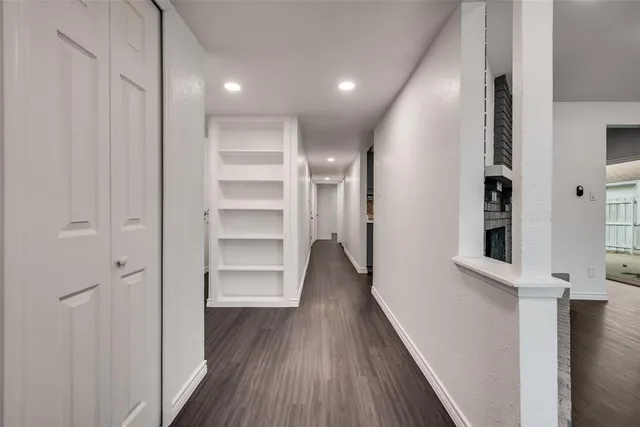 a view of a hallway with wooden floor and closet