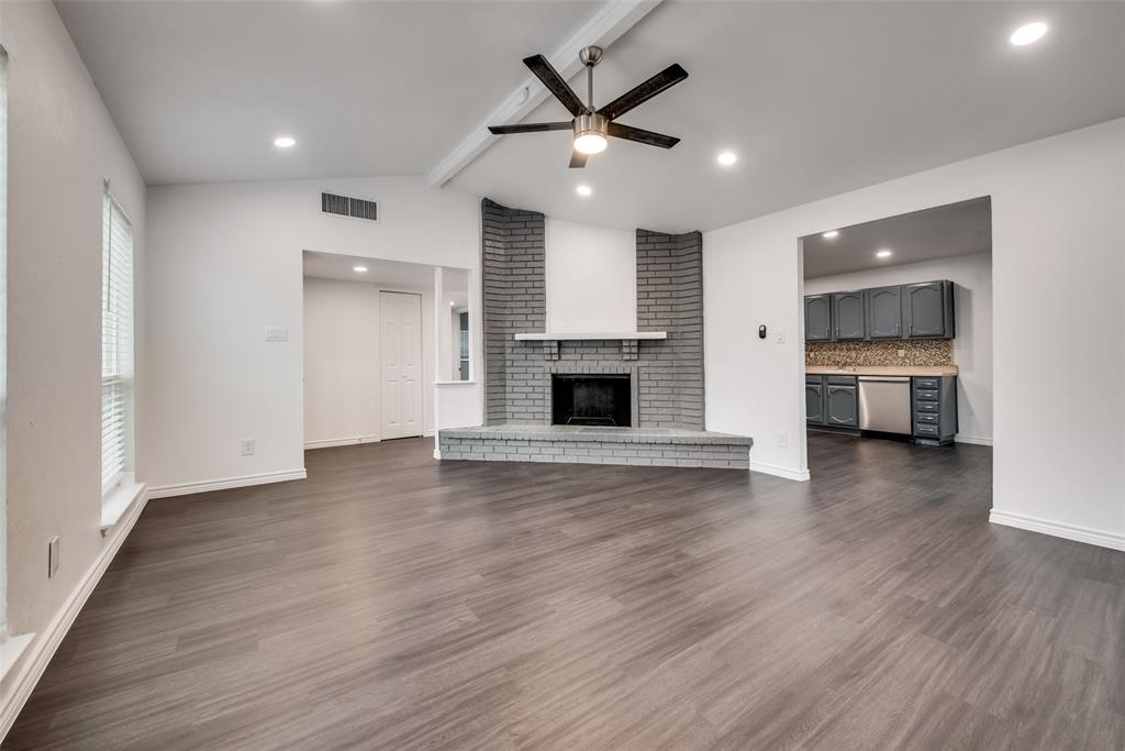 5412 Rice Drive The Colony, TX 75056 - Photo 6 of 17 an empty room with wooden floor and a kitchen