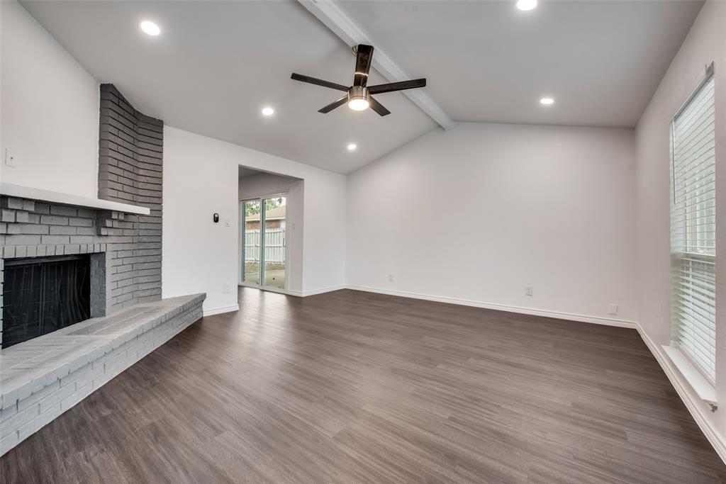 5412 Rice Drive The Colony, TX 75056 - Photo 7 of 17 an empty room with wooden floor fireplace and windows