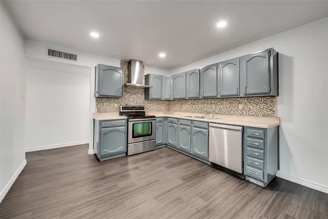 a kitchen with stainless steel appliances granite countertop a stove a sink and a refrigerator