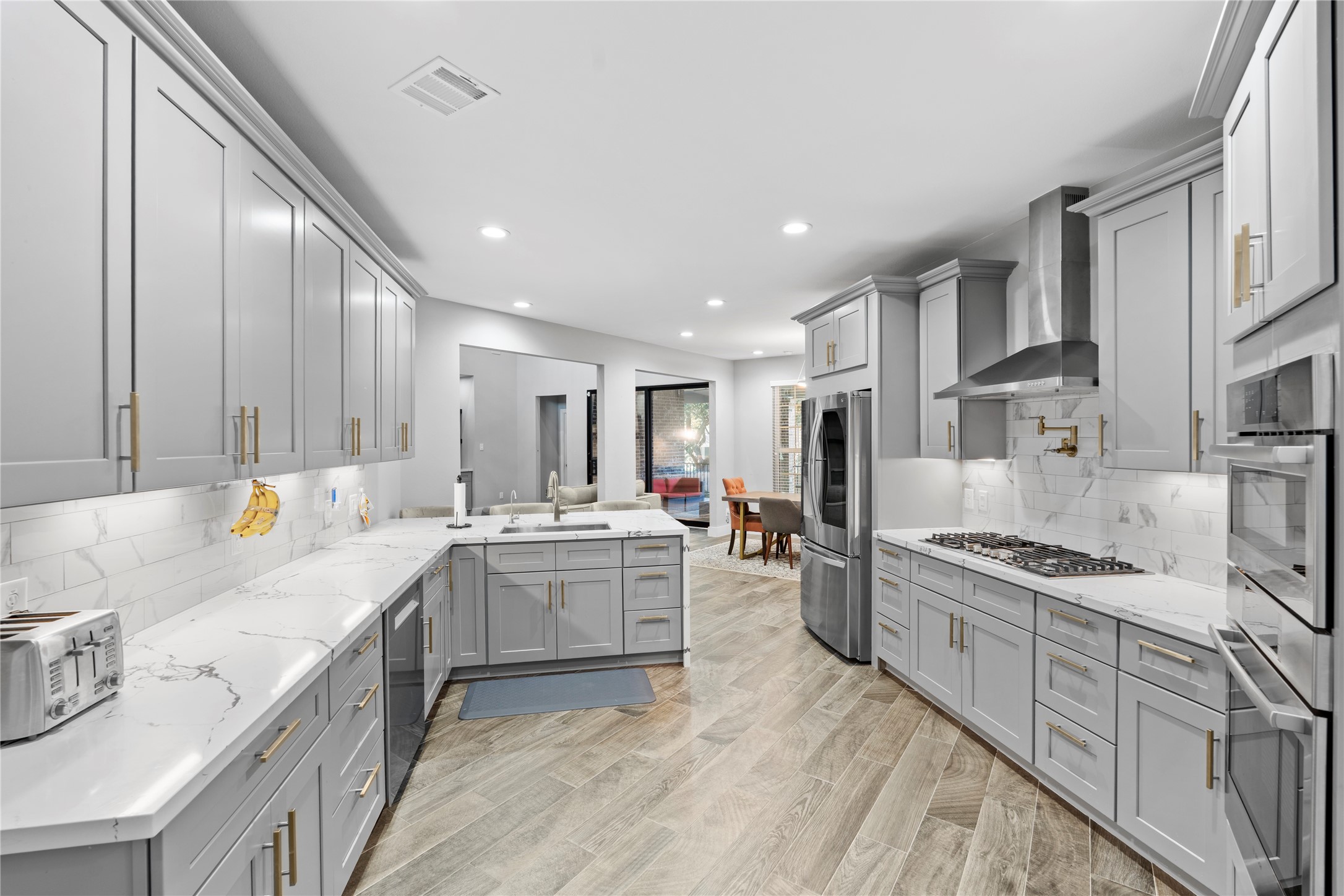 6207 Graff Net Court Spring, TX 77379 - Photo 4 of 49 Elegant kitchen with sleek finishes, gas stove, and high-end appliances, designed for both style and function.