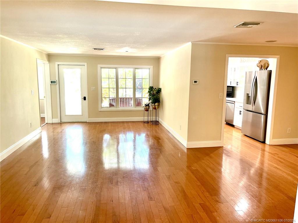 4 Emarita Way Stuart, FL 34996 - Photo 16 of 47 a view of an empty room with wooden floor and a window