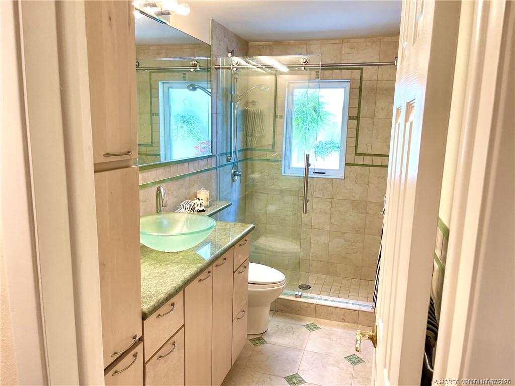 4 Emarita Way Stuart, FL 34996 - Photo 27 of 47 a bathroom with a granite countertop sink a toilet and shower