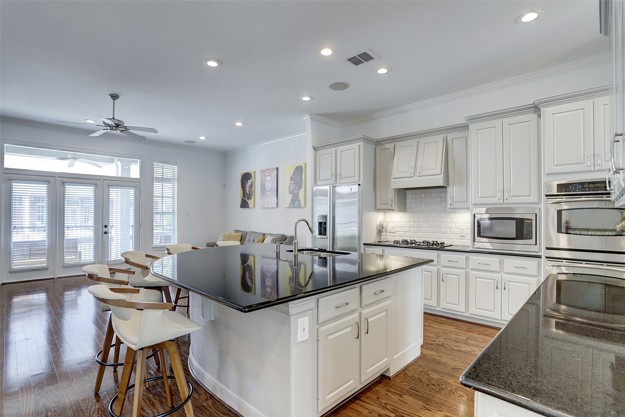 10 Shell Port Square The Woodlands, TX 77380 - Photo 13 of 31 a kitchen with stainless steel appliances granite countertop a stove top oven a sink dishwasher a dining table and chairs with wooden floor