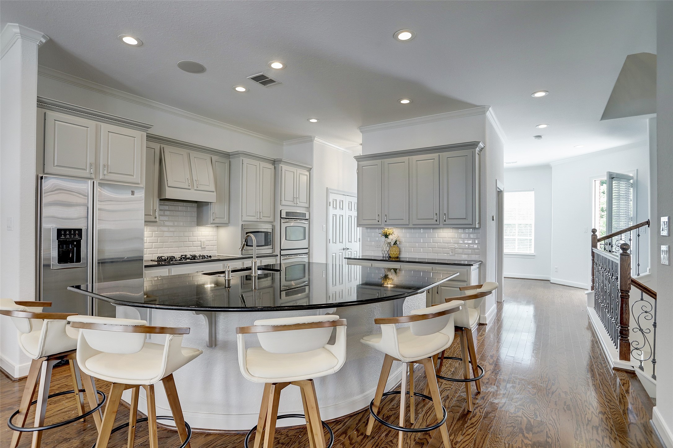 10 Shell Port Square The Woodlands, TX 77380 - Photo 14 of 31 a kitchen with stainless steel appliances kitchen island granite countertop a kitchen island a stove a table and chairs