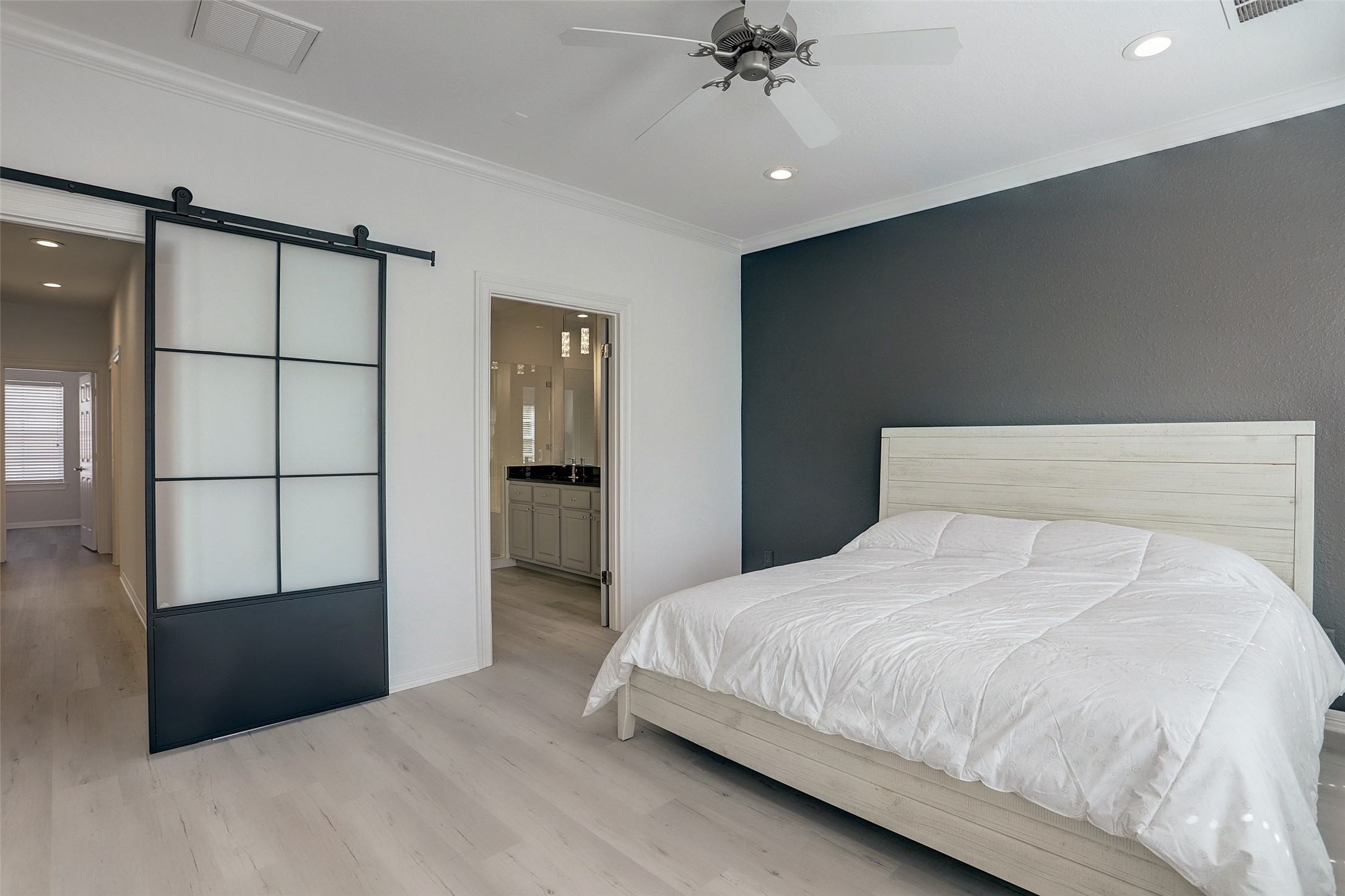 10 Shell Port Square The Woodlands, TX 77380 - Photo 22 of 31 a bedroom with a large bed and a chandelier