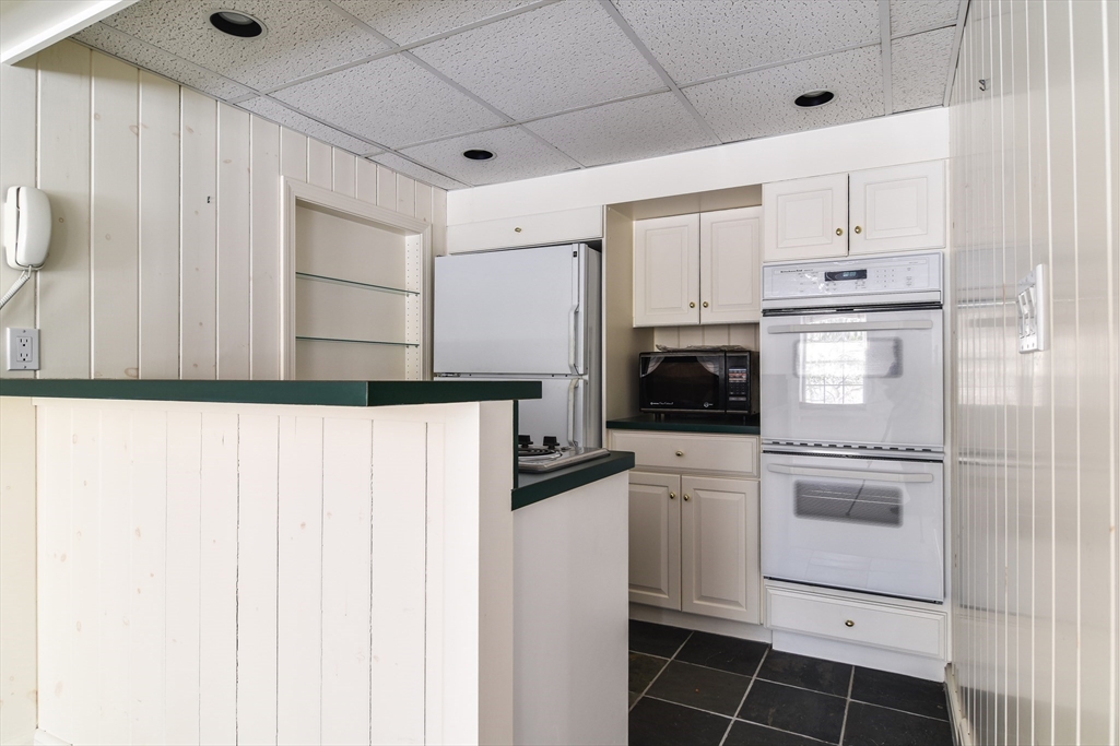 9 Buttercup Lane Dover, MA 02030 - Photo 28 of 36 a kitchen with white cabinets and white appliances