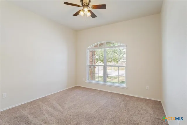 an empty room with a chandelier fan