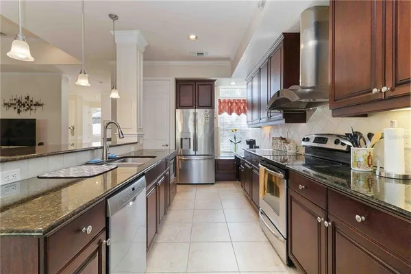 a kitchen with stainless steel appliances granite countertop a sink a stove and a refrigerator