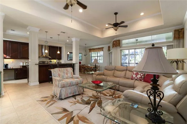 a living room with furniture kitchen view and a wooden floor