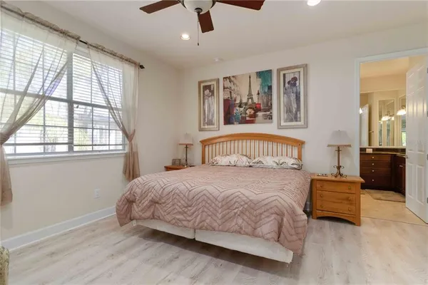 a bedroom with a bed next to a window with a chandelier