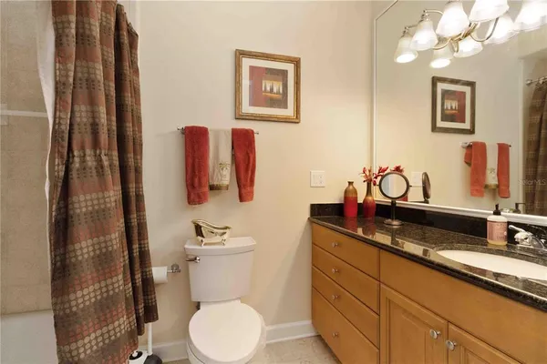 a bathroom with a granite countertop sink mirror vanity and toilet