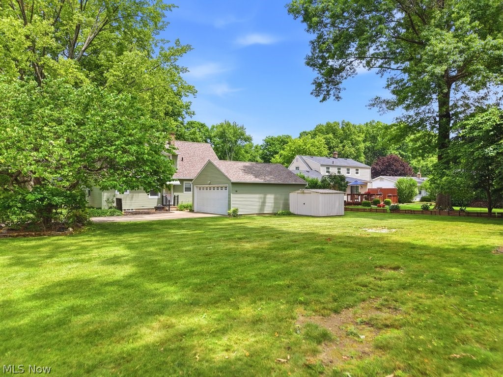 161 Pinehurst Road Munroe Falls, OH 44262 - Photo 36 of 40 Backyard with green grass and a garage with mature trees