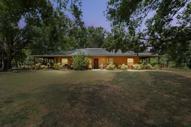 a view of swimming pool with outdoor seating and covered with trees
