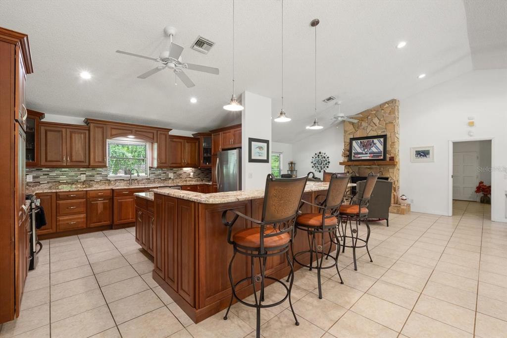 13719 Seminole Trail Wimauma, FL 33598 - Photo 15 of 68 a kitchen with stainless steel appliances granite countertop a stove top oven a sink a dining table and chairs
