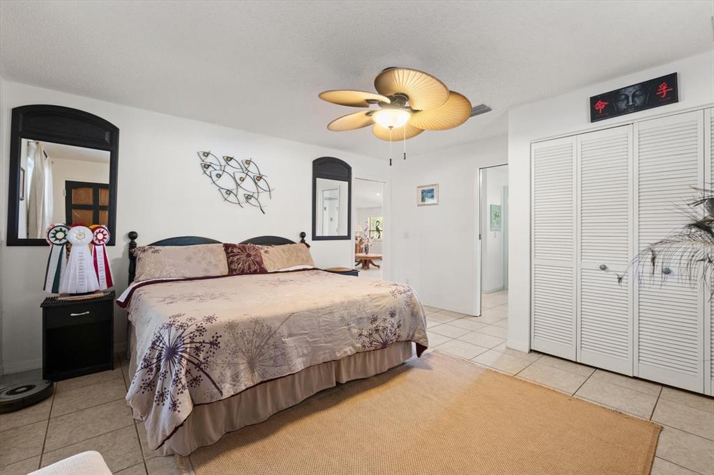 13719 Seminole Trail Wimauma, FL 33598 - Photo 30 of 68 a bedroom with bed and a chandelier