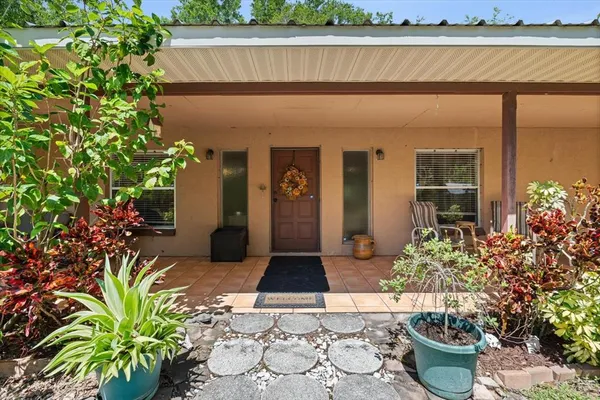 a living room with patio furniture and kitchen view