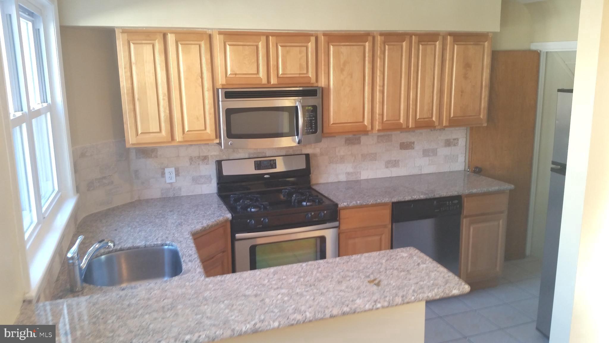 3612 Winona Street Philadelphia, PA 19129 - Photo 2 of 10 a kitchen with granite countertop a sink stove and cabinets