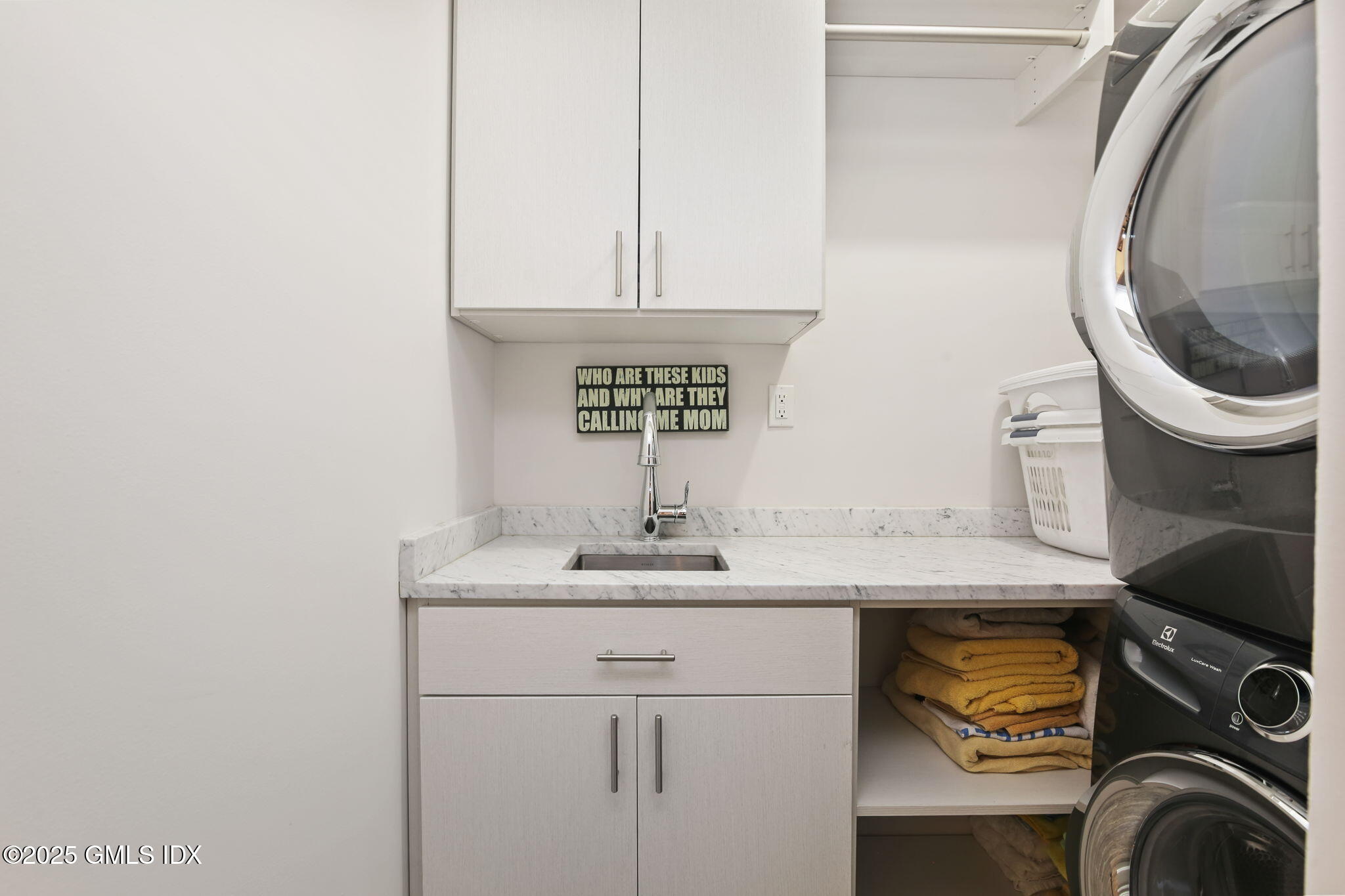 50 Sound View Drive, Unit 4N Greenwich, CT 06830 - Photo 18 of 20 a bathroom with a sink and a washer dryer