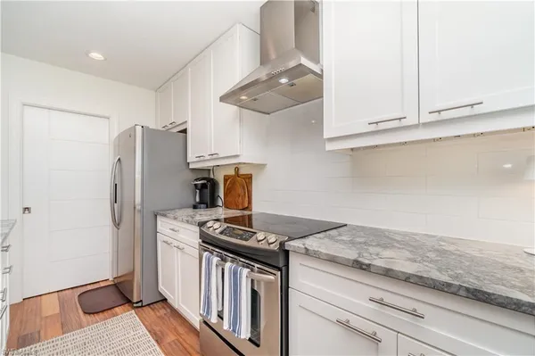 a kitchen with stainless steel appliances granite countertop a refrigerator and a stove