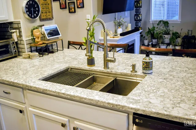 a kitchen with kitchen island granite countertop a sink a stove and a wooden floor