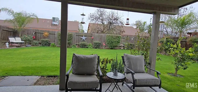 a view of a chair and table in backyard of the house