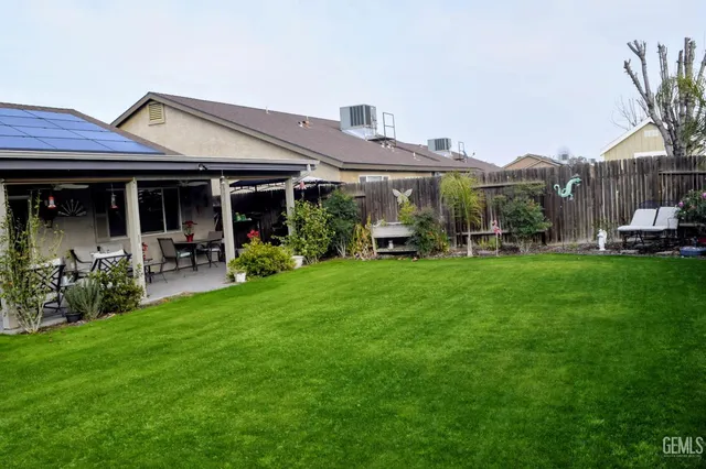 a view of a house with backyard sitting area and garden