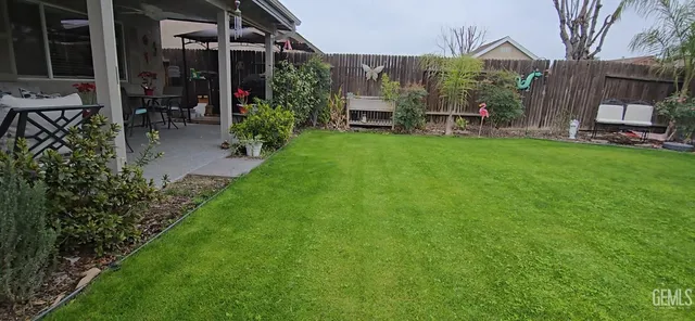 a view of a chair and table in backyard of the house