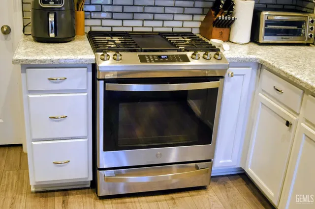 a stove top oven sitting inside of a kitchen