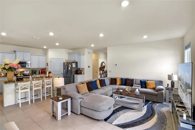 a living room with furniture and a view of kitchen
