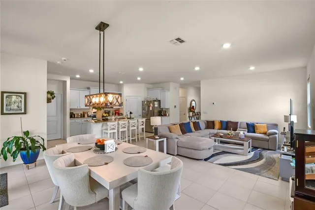 a living room with furniture kitchen view and a chandelier