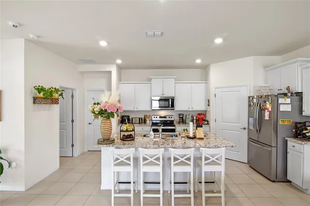 a kitchen with refrigerator and chairs