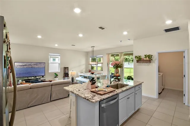 a kitchen with stainless steel appliances kitchen island granite countertop a sink and cabinets
