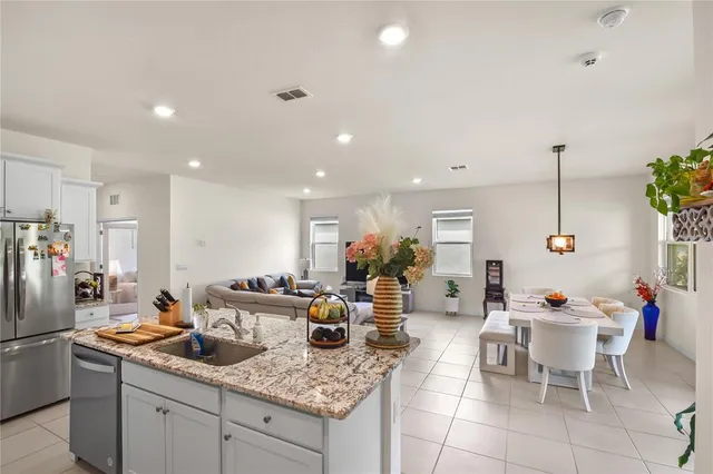 a kitchen with a sink dining table and chairs