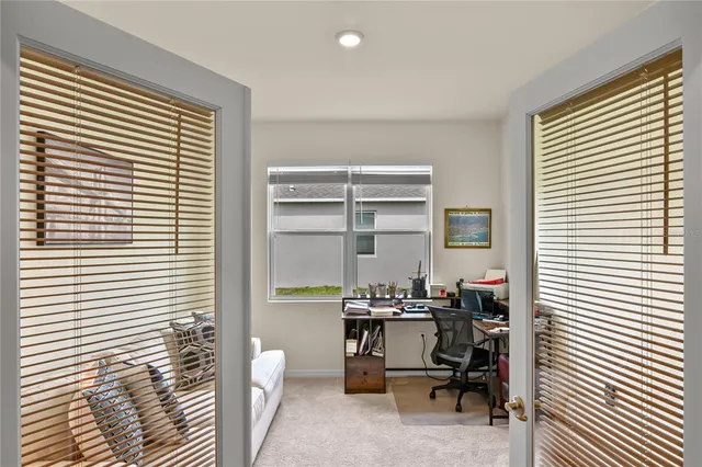 a view of a workspace with furniture and a window