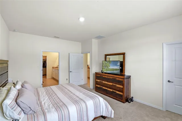 a bedroom with a bed and a painting on the wall