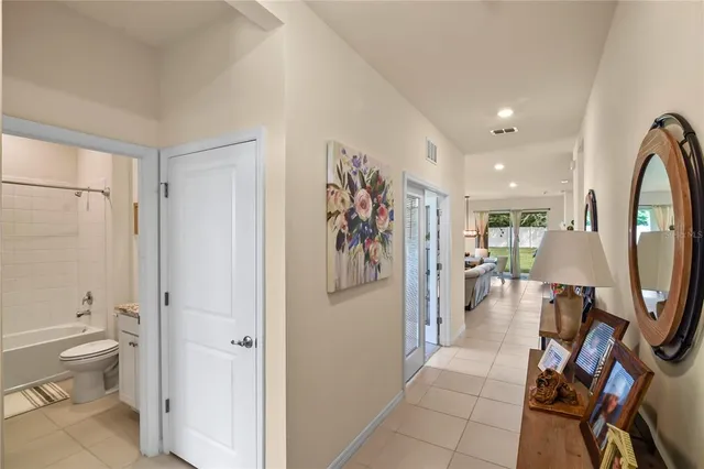 a view of a hallway with bathroom and mirror