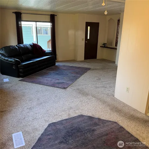 a living room with a large bed and a dresser