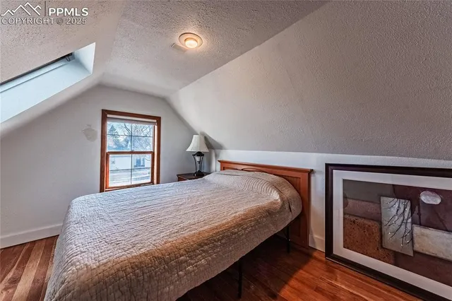 a bedroom with a bed and a painting on the wall