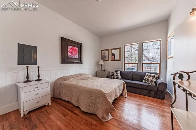 a bedroom with a bed a dresser and windows