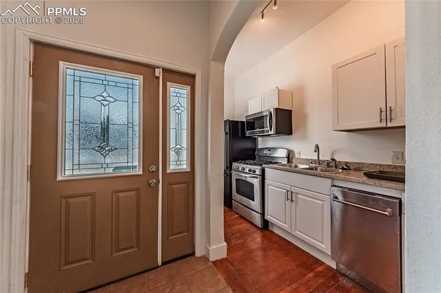 a kitchen with stainless steel appliances granite countertop a sink stove and microwave