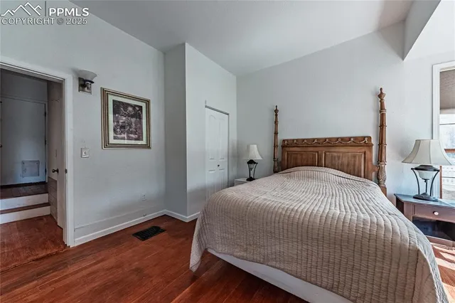 a bedroom with a bed and a large mirror next to a window