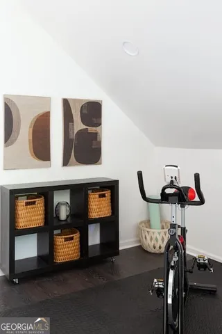 a open kitchen with stainless steel appliances granite countertop a stove a refrigerator and a dining table with wooden floor