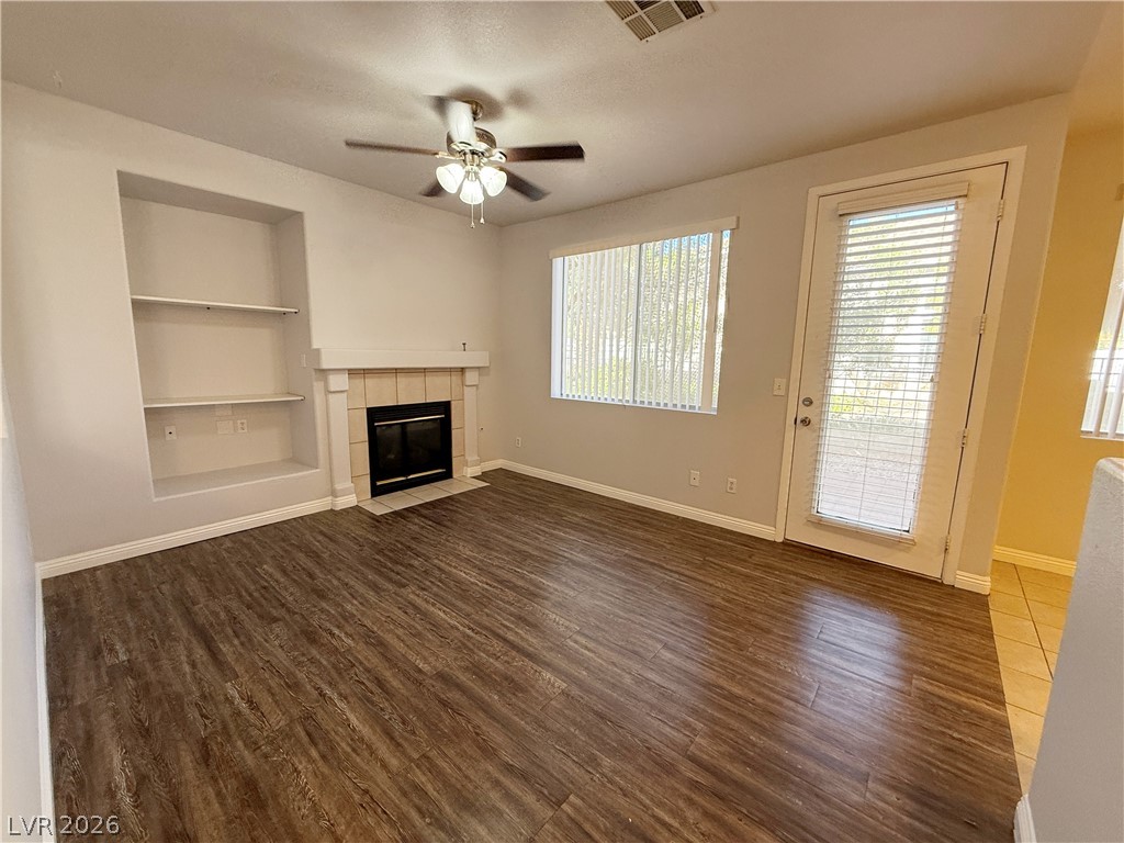 2185 Polynesia Circle Henderson, NV 89074 - Photo 8 of 37 A cozy living space features built-in shelving, a fireplace, and durable laminate flooring.